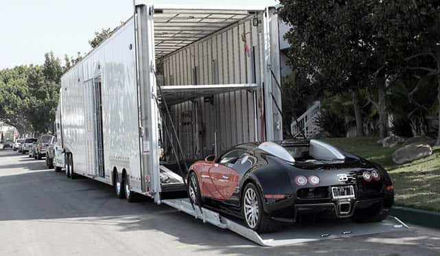 Luxury car being loaded inside an enclosed transport truck for safe vehicle relocation by L-Trans Cargo Movers.
